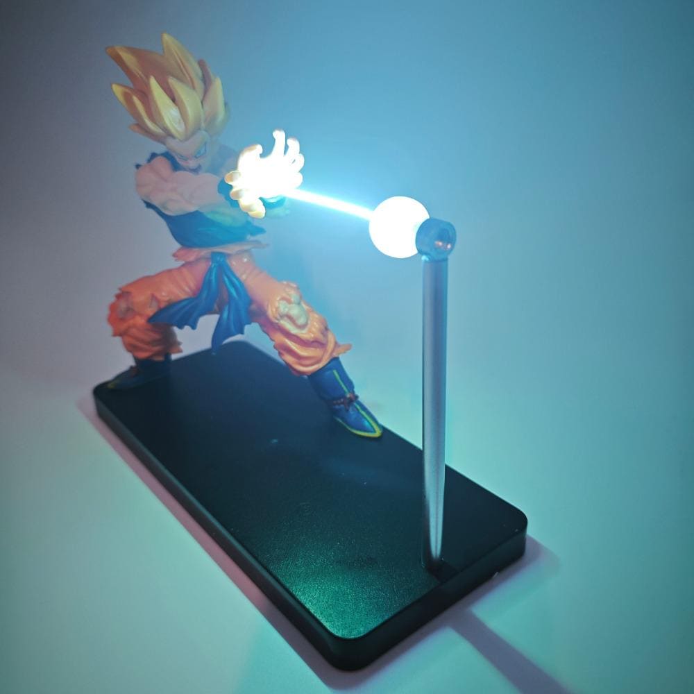 Character figurine with a light-up weapon on a stand against a blue background