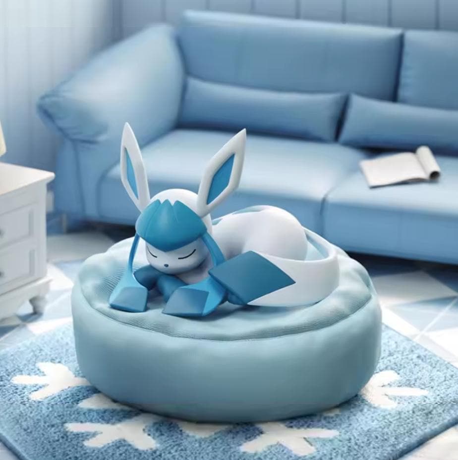 Glaceon sleeping soundly on a textured light blue pillow with embroidered snowflake details, premium PVC Pokémon statue for collectors.